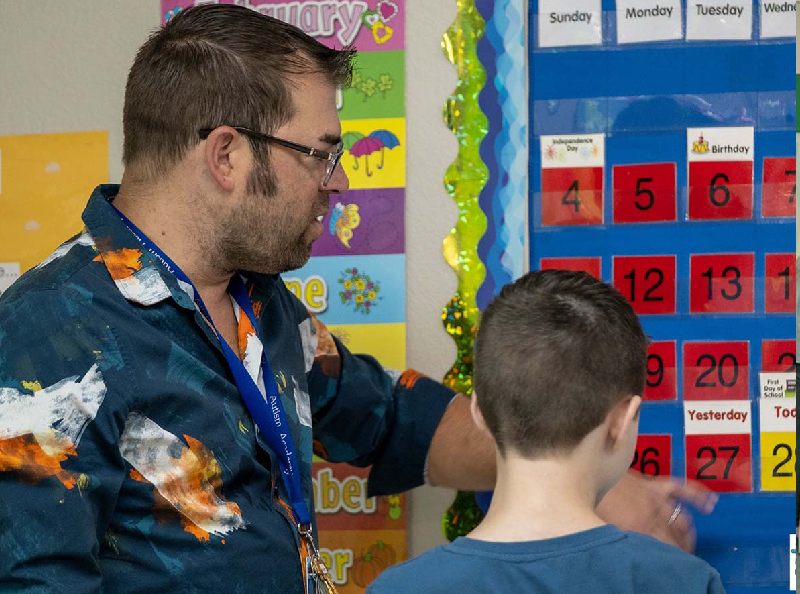 man teaching child with autism